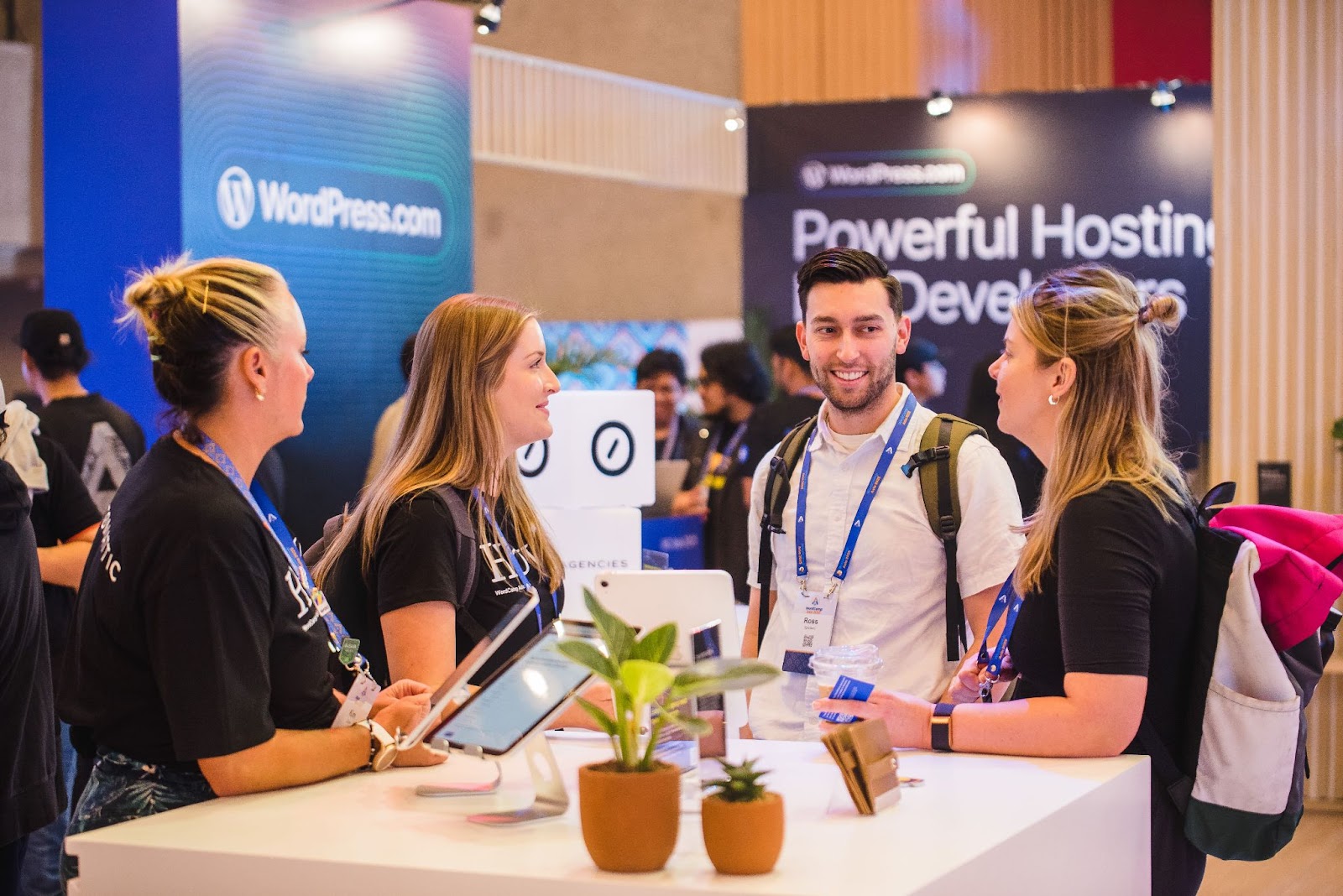 people visiting with Automattic for Agencies team members at their booth