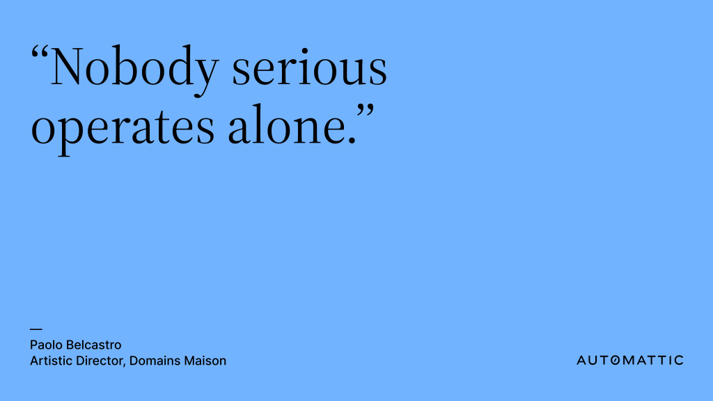 Large text that reads "Nobody serious operates alone" on a light blue background. Smaller text below that reads, "Paolo Belcastro, Artistic Director, Domains Maison" and the Automattic logo.
